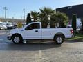 A white 2018 Ford F-150 pickup truck parked with a smooth side profile showcasing its streamlined design and four doors