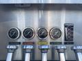 Four circular pressure gauges in metal frames labeled Rear Discharge No 2 Discharge Monitor and No 2 Preconnect alongside a water level indicator and valves