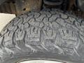 Close-up of a rugged tire with deep treads suitable for off-road use mounted on a 2010 Ford Econoline