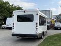 A white 2020 Chevrolet Express van with a rectangular rear window and rear lights visible parked in a lot