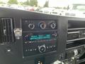 Dashboard of a 2016 Chevrolet Express displaying controls for climate settings and a sound system with a digital screen