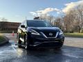 A black 2021 Nissan Murano is parked, showcasing its sleek design with prominent headlights and a distinctive front grille
