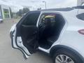 A 2018 Buick Encore with an open passenger door revealing leather seats and a spacious interior