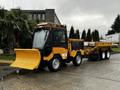 A yellow 2015 International 3000 MT6 vehicle equipped with a snow plow in front and a large trailer in the back