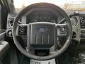 Steering wheel of a 2016 Ford F-550 with controls on either side and a Ford logo prominently displayed in the center
