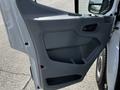 A close-up of the interior door panel of a 2018 Ford Transit featuring a gray plastic design with a small handle and storage compartment