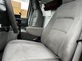 Interior of a 2009 Ford Econoline showing grey fabric seats with armrests and a steering wheel in the foreground