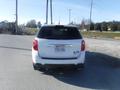 A 2011 Chevrolet Equinox parked with a white rear facing the camera displaying a license plate and a small sticker on the bumper