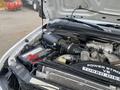 Close-up of the engine compartment of a 2009 Ford F-450 SD featuring a Power Stroke V8 Turbo Diesel engine and visible components like the battery and intercooler