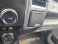 Dashboard controls of a 2017 Ford F-550 featuring a tuning knob and a 12V power outlet
