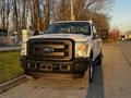 A white 2012 Ford F-250 pickup truck with a black grille and front bumper positioned on a paved surface