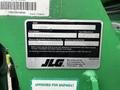 A green label displaying specifications for a 2014 JLG 10054 model including serial number maximum weight and capacity information