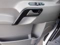 Close-up of the interior door panel of a 2016 Mercedes-Benz Sprinter featuring a door handle power window controls and a storage compartment