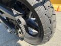 Close-up of a 2021 Harley-Davidson RA1250 S motorcycle tire showcasing tread pattern and chain mechanism