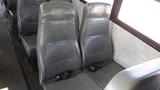 Two gray bus seats with seat belts in a row inside a bus