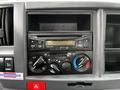 Interior dashboard controls of a 2018 Isuzu NPR featuring various dials buttons and a digital display for climate and audio settings