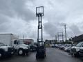 A 2011 Toyota 028FG15 forklift stands upright with a raised fork assembly ready for lifting in a parking lot filled with vehicles