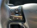 Close-up of the steering wheel controls of a 2023 Ford Transit featuring buttons for cruise control and audio settings