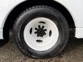 A close-up of a white wheel and tire from a 2009 Ford Econoline featuring a black hubcap and a winter tire with the label Extreme Grip Winter Claw