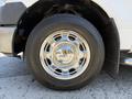 A close-up of a chrome wheel rim and tire of a 2014 Ford F-150 with a shiny surface and distinctive multi-spoke design