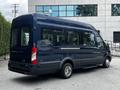A 2017 Ford Transit 350 in dark blue with a high roof and large windows is parked with its back partially visible showing its sleek design and distinctive shape
