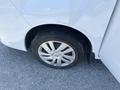 A close-up of a flat tire on a silver 2019 Nissan NV200 van showing the wheel rim and tire without any visible air