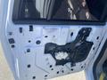 A disassembled door panel of a 2013 Ford Expedition showing internal components such as wiring and a motor mechanism