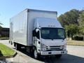 A 2019 Isuzu NRR box truck with a white exterior and a large cargo area in the back is parked with its front facing towards the viewer