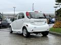 A white 2013 Mitsubishi i-MiEV parked with its rear facing the camera showcasing its compact design and unique shape