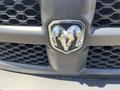 Close-up of the chrome RAM logo featuring two ram heads set against a black grille with a honeycomb pattern