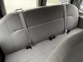 The interior of a 2013 Ford E-350 showing a gray bench seat with seat belts attached