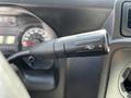 A black turn signal lever from the steering column of a 2019 Ford Econoline with a textured grip and control markings visible