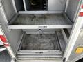 A 2009 Ford F-550 ambulance with empty storage compartments showcasing sliding shelves in the rear cargo area