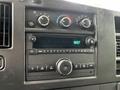 Interior dashboard control panel of a 2023 GMC Savana featuring climate controls and audio system with digital clock display