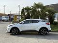 A 2021 Toyota C-HR in white parked with a sleek profile showcasing its aerodynamic design and sporty features