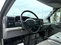 Interior view of a 2004 Ford F-750 featuring a steering wheel dashboard controls and gear shifter