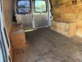 Interior of a 2012 Chevrolet Express van featuring wooden benches on either side and a wooden floor with exposed plywood walls