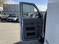A 2012 Ford Econoline E-450 with its driver side door open showcasing the interior door panel and handle