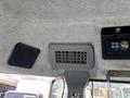 Interior ceiling of a 2010 New Holland T4050 with a speaker and a ventilation grille visible along with a control panel