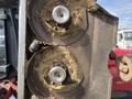 Close-up of two circular mower blades from a 2014 Toro Groundmaster 5910 covered in grass clippings with shiny metal discs and a rusted metal casing