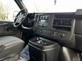 Interior of a 2015 Chevrolet Express showing the dashboard with controls and a center console with cup holders