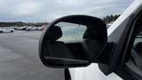 A side mirror of a 2013 Chevrolet Silverado 1500 reflecting the interior of the vehicle with a dark seat visible