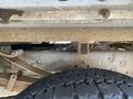 A close-up view of the undercarriage of a 2015 Ford F-550 showing the tire and metal components including a suspension system and cross member