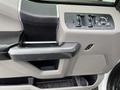 The interior door handle and control panel of a 2016 Ford F-150 featuring window controls and a speaker mesh