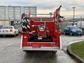 A red 2001 Toyota Dyna fire truck with visible hoses and a pump located at the rear of the vehicle