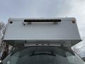 A rear view of a white 2006 GMC C5000 with a boxy cargo area and a light bar mounted on top