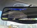 A 2016 Ford F-150's rearview mirror displaying a rearview camera feed with guidelines indicating the parking path