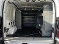 Empty interior of a 2017 Ford Transit van with metal shelves on both sides and a black rubberized floor