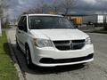 A white 2011 Dodge Grand Caravan parked with a visible front view featuring the distinctive grille and headlights