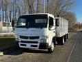 A 2014 Mitsubishi Fuso FE truck with a flatbed and multiple side compartments parked on a road